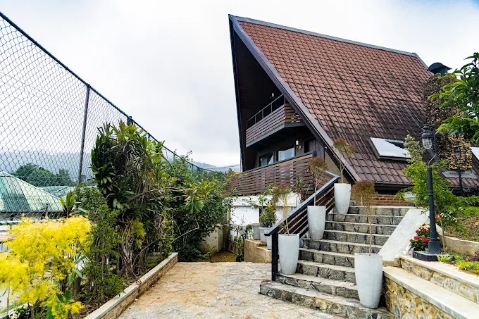 The Kubana A-frame chalet with stone steps leading up through the garden