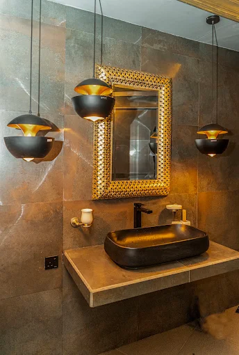 Black basin, gold mirror and brass pendant lamps
