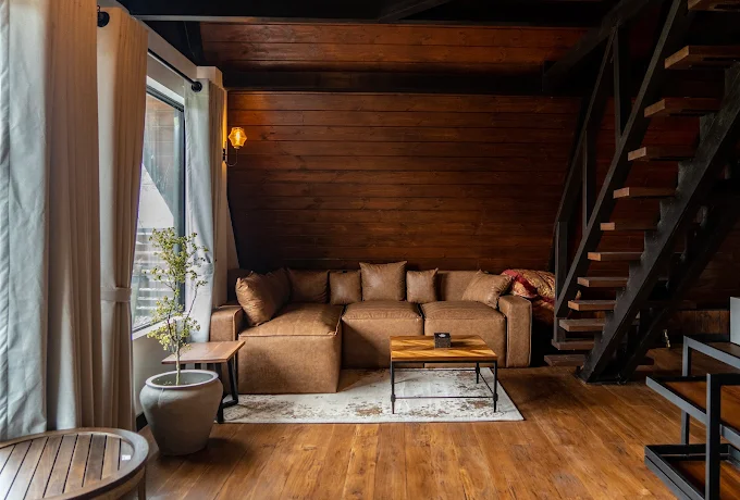 Leather sofa against a timber wall beside the open staircase
